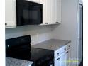 Modern kitchen featuring white cabinets, updated appliances, and stylish countertops at 5855 Amity Springs Dr, Charlotte, NC 28212