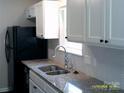 A well-designed kitchen featuring stainless steel sink, granite countertops, and white cabinets at 5855 Amity Springs Dr, Charlotte, NC 28212