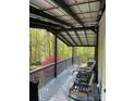 Relaxing covered porch with outdoor seating, perfect for enjoying the peaceful, wooded surroundings at 6490 Alta Ctr, Denver, NC 28037