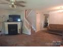 Cozy living room featuring a fireplace and staircase to the upper level at 7857 Petrea Ln, Charlotte, NC 28227
