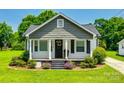 Charming home features a gray roof, flower beds, and a cozy porch with a seating area at 903 Rhode Island Ave, Kannapolis, NC 28083