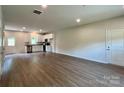 Bright open-concept space with hardwood flooring connecting the living area to the kitchen at 907 W Georgia Ave, Bessemer City, NC 28016