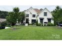 Charming white brick home with manicured lawn and garden, creating a welcoming curb appeal at 9604 Oliver Ct, Harrisburg, NC 28075