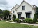Beautiful white brick home with manicured lawn, garden, and a curved walkway to the front door at 9604 Oliver Ct, Harrisburg, NC 28075
