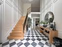 Grand foyer featuring a black and white checkered marble floor, staircase, and stylish decor at 9604 Oliver Ct, Harrisburg, NC 28075