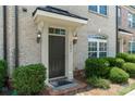 Inviting front door with elegant architectural trim, sconces, and manicured bushes at 1027 Writers Way, Cornelius, NC 28031