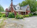 Lovely brick home with an upstairs deck and a cozy front porch, surrounded by lush landscaping at 1102 Lane St, Kannapolis, NC 28083