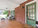 Inviting covered front porch featuring seating, a wooden deck, and a view of the landscaped yard at 1102 Lane St, Kannapolis, NC 28083