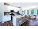 Modern kitchen with white cabinets, stainless steel appliances, and a spacious island with seating at 11021 Warfield Ave # 03, Huntersville, NC 28078