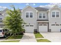 Attractive townhouse exterior with a stone accents, white garage doors, and well-maintained landscaping at 13323 Savaine St, Charlotte, NC 28278