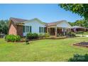 Landscaped front yard of a charming brick home featuring lush green lawn and well-maintained flower beds at 1553 Home Trl # 51, Lincolnton, NC 28092