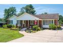 Charming brick home featuring mature trees, well-kept landscaping, and a welcoming front porch perfect for relaxing at 1553 Home Trl # 51, Lincolnton, NC 28092