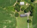 Aerial view showcases the home's placement on a large lot with surrounding trees and farmland at 1904 Old Peachland Rd, Marshville, NC 28103