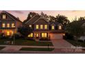 Exterior shot of a lovely two-story home at dusk with landscaped yard and attached two-car garage at 2377 Maple Grove Nw Ln, Concord, NC 28027