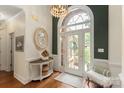Elegant foyer featuring a hardwood floor, chandelier, decorative mirror and ample natural light from the front door at 3003 Wedge Ct, Matthews, NC 28104