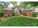Beautiful brick home with a well-maintained lawn, attractive landscaping, and inviting walkway to front door at 3003 Wedge Ct, Matthews, NC 28104