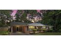 Inviting brick home with a carport against a twilight sky, complemented by verdant trees and fresh landscaping at 4322 Greenhaven Ln, Gastonia, NC 28056