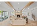 Bright living room featuring hardwood floors, fireplace, exposed beams, and access to outdoor patio at 4349 Castleton Rd, Charlotte, NC 28211