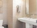 This neutral-toned powder room features a pedestal sink, patterned wallpaper, and minimalist decor at 628 Cherry St, Charlotte, NC 28204