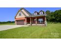 Charming two-story home with a well-maintained lawn and a two-car garage at 670 Cricket Ln, Mt Ulla, NC 28125