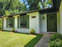 Inviting front entrance showcases a well-maintained lawn, green door, and white brick exterior, exuding curb appeal at 7228 Rollingridge Dr, Charlotte, NC 28211