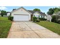 Single-story home with a two-car garage, concrete driveway, and well-maintained lawn at 7616 Shiny Meadow Ln, Charlotte, NC 28215