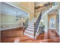 Grand foyer showcasing hardwood floors, staircase with iron railings, and elegant chandelier at 844 Clonmel Dr, Matthews, NC 28104