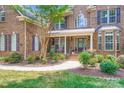 Charming brick home with a manicured lawn, mature trees, and a welcoming front porch at 844 Clonmel Dr, Matthews, NC 28104