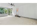 A screened-in porch with a ceiling fan, a door to outside, and views of the trees at 9833 White Cascade Dr, Charlotte, NC 28269