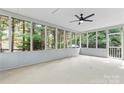 A screened-in porch with a ceiling fan, and views of the surrounding trees at 9833 White Cascade Dr, Charlotte, NC 28269
