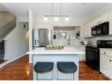 Stylish kitchen featuring a central island with seating, stainless steel appliances, and hardwood floors at 10094 Treeside Ln, Matthews, NC 28105
