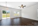 Bright, open living area with wood floors, a modern ceiling fan, and sliding glass doors leading to the backyard at 1209 Cathey Rd, Charlotte, NC 28214