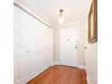 Hallway with wood floors, coat closet and detailed light fixture by front door at 1300 Reece Rd # 402, Charlotte, NC 28209
