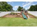 Large backyard featuring a multi-tiered play area and garden at 133 Glade Valley Ave, Mooresville, NC 28117