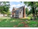Rear exterior view showing the brick, gray siding, screened porch, and surrounding green lawn at 1581 Bluff Ct, Rock Hill, SC 29732