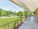 Inviting covered front porch with decorative iron railing and column supports at 1606 N Rhyne St, Gastonia, NC 28054