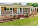 Charming brick home with a cozy front porch and black iron railings at 1606 N Rhyne St, Gastonia, NC 28054