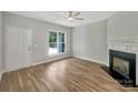 Bright living room with a fireplace, a ceiling fan and large windows for natural light at 16815 Spruell St, Huntersville, NC 28078