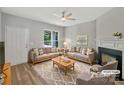 Bright living room with neutral decor, a cozy fireplace, and large windows for natural light at 16815 Spruell St, Huntersville, NC 28078