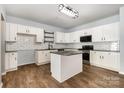 Bright kitchen with an island, white cabinets, granite counters, stainless steel appliances, and modern light fixtures at 172 Briana Marie Way, Indian Trail, NC 28079