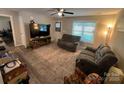 Bright living room features neutral walls, large window and reclining sofa set at 1723 Lowder St, Albemarle, NC 28001