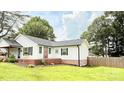 A classic home with white siding, contrasted by dark shutters and complemented by a lush, green lawn at 210 W Church St, Cherryville, NC 28021