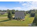 Quaint one-story home surrounded by a lush green lawn, mature trees, and a basketball hoop at 2268 Bay Ct, Newton, NC 28658