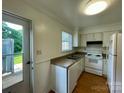 Functional kitchen featuring white appliances, a double sink, and a door leading to the outside at 250 Nixon Rd # 41, Belmont, NC 28012