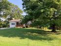 Single story home with brick facade shaded by a large tree and a lush green lawn at 3009 Grier St, Newton, NC 28658