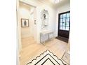 Inviting entryway with light hardwood flooring, decorated table, and decorative mirror at 3011 Ella Katherine Way, Charlotte, NC 28210