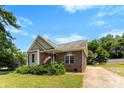 Quaint brick home with a well-maintained lawn, complemented by mature trees and a basketball hoop at 400 N Main Gq St, Granite Quarry, NC 28146