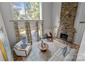 Bright living room featuring a stone fireplace and large windows offering a serene view at 4208 Burning Tree Dr, Charlotte, NC 28277