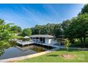 Stunning waterfront property featuring a private dock with a boat house and pier for outdoor enjoyment at 47209 Paradise Ln, Norwood, NC 28128