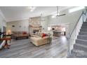 Inviting living room featuring a stone fireplace, ceiling fan, and easy access to the modern kitchen at 47209 Paradise Ln, Norwood, NC 28128